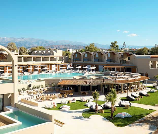 Et moderne hotell med bassengområde og frodig hage, samt fjell i bakgrunnen. (AI-generert tekst)