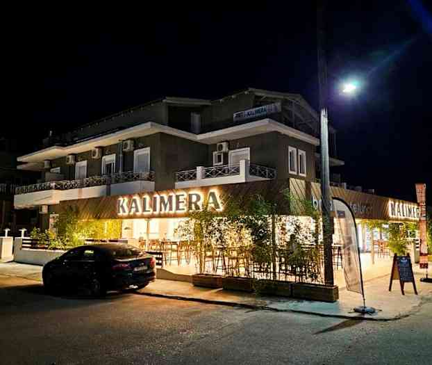 En bygningfasade med skiltet 'KALIMERA', tatt om kvelden. (AI-generert tekst)