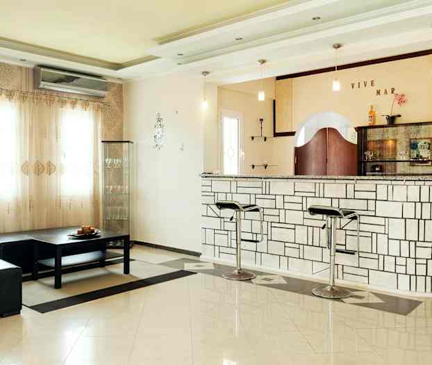 Et rom med bar og sittegruppe. (AI-generert tekst)