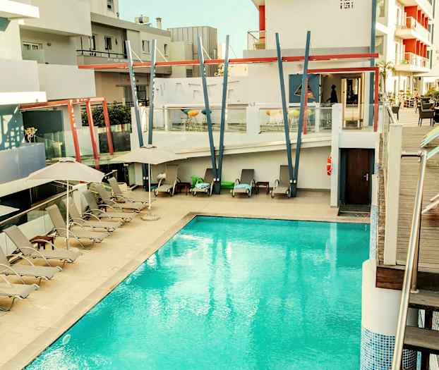 Utendørs basseng ved et moderne hotell med solsenger og parasoller. (AI-generert tekst)