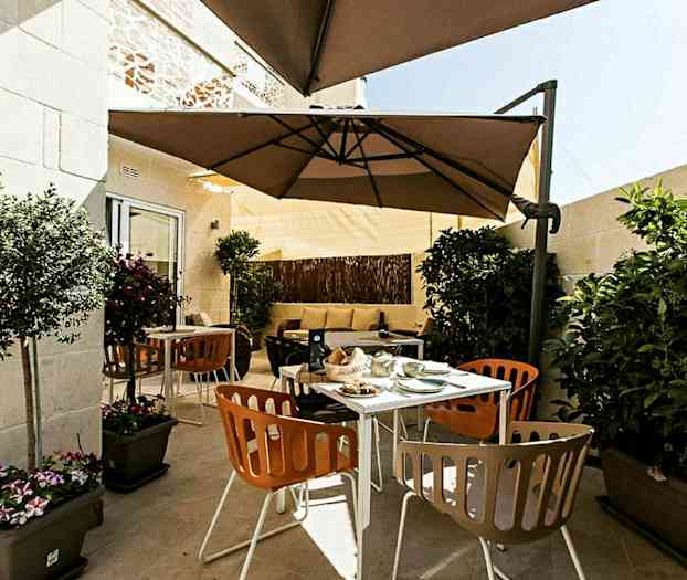 En terrasse med utemøbler, parasoll og planter. (AI-generert tekst)