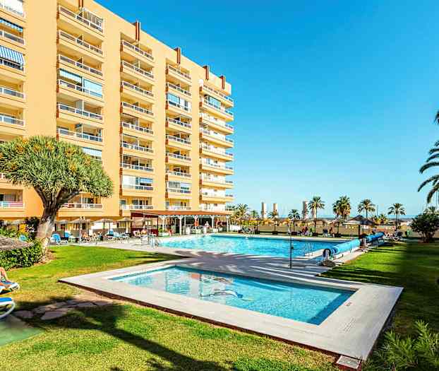 Hotellbygning med basseng og hage. (AI-generert tekst)