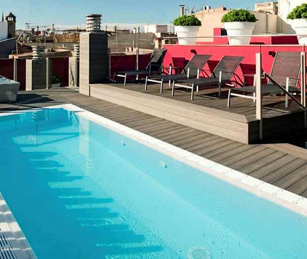 Takbasseng omgitt av tregulv og solsenger, med utsikt over bymiljø. (AI-generert tekst)