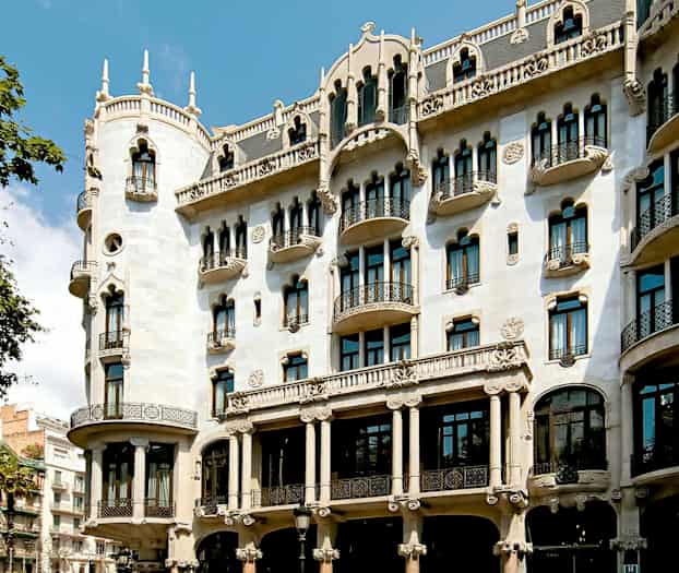 Et bilde av en dekorativ bygning med utsmykket fasade, balkonger og buede vinduer. (AI-generert tekst)