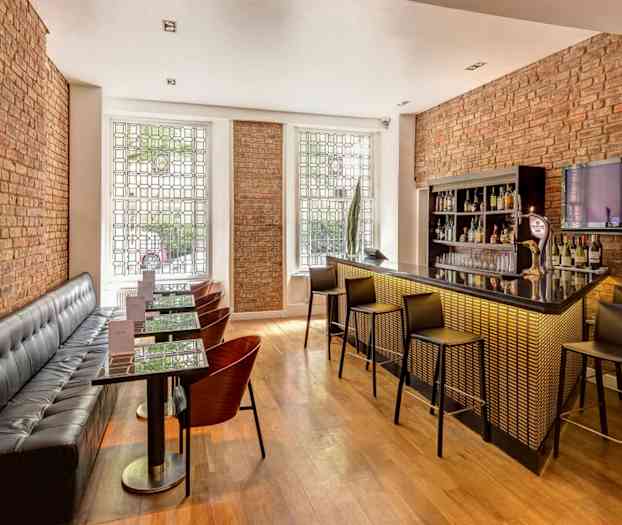 Moderne designet bar med sitteplasser og murvegger. (AI-generert tekst)