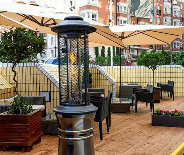 Terrasse med møbler og varmeapparat på et tregulv. (AI-generert tekst)