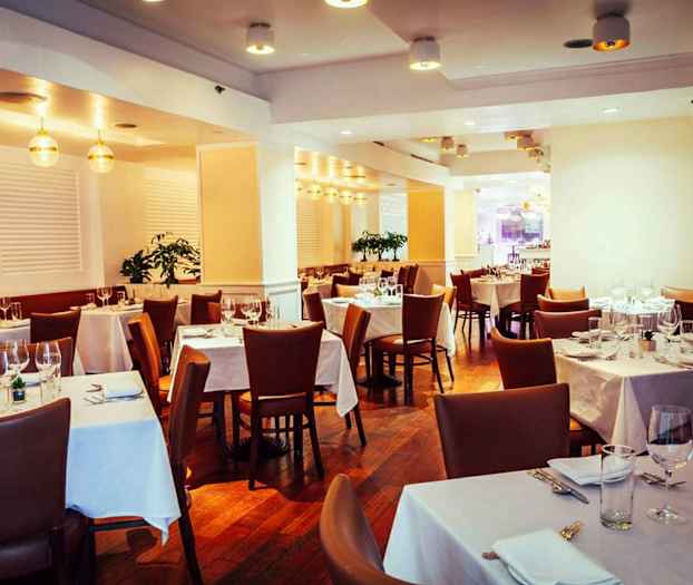 En elegant restaurant med bord dekket og brune stoler. (AI-generert tekst)