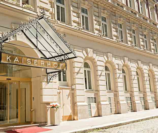 Hotellbygning med inngang og skilt som lyder "Hotel Kaiserhof". (AI-generert tekst)