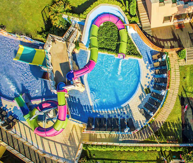 Luftfoto av et basseng med vannsklier og solsenger rundt. (AI-generert tekst)