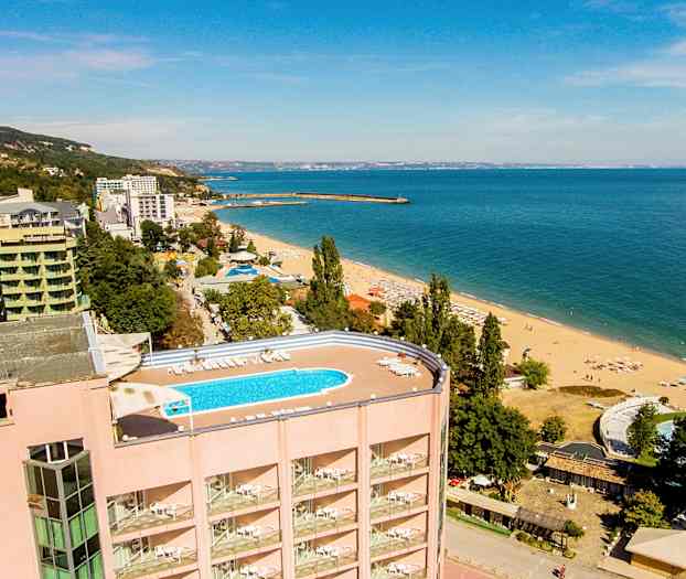 Utsikt over en strand med hotell og basseng. (AI-generert tekst)