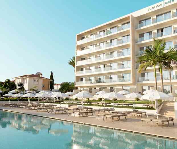 Moderne hotell med stort utendørsbasseng, hvite parasoller og solsenger. (AI-generert tekst)