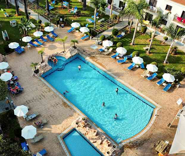 Luftfoto av et basseng med omkringliggende solsenger og parasoller. (AI-generert tekst)