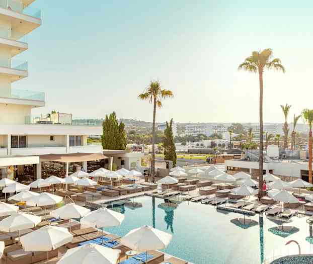 Hotellutsikt med basseng, solsenger og parasoller. (AI-generert tekst)