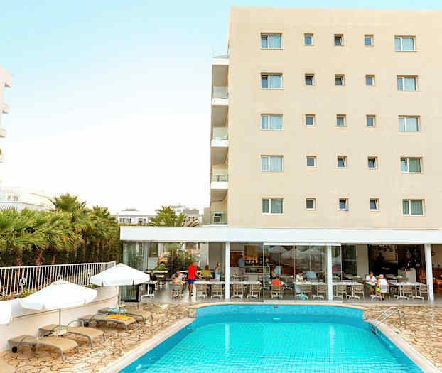 Hotellbygning med svømmebasseng og solsenger foran. Folk sitter ved restauranten. (AI-generert tekst)