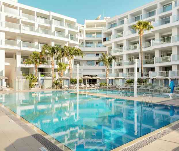 En moderne bygning med balkonger omgir et utendørs basseng. (AI-generert tekst)