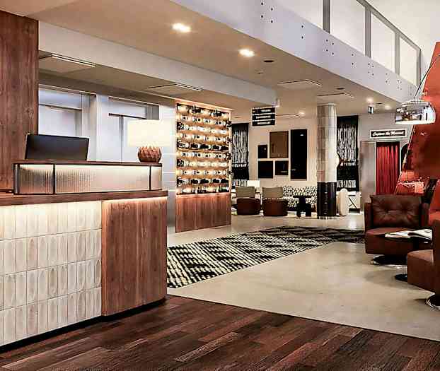 Hotellobby med resepsjonsdisk, sittemøbler og dekorativ belysning. (AI-generert tekst)