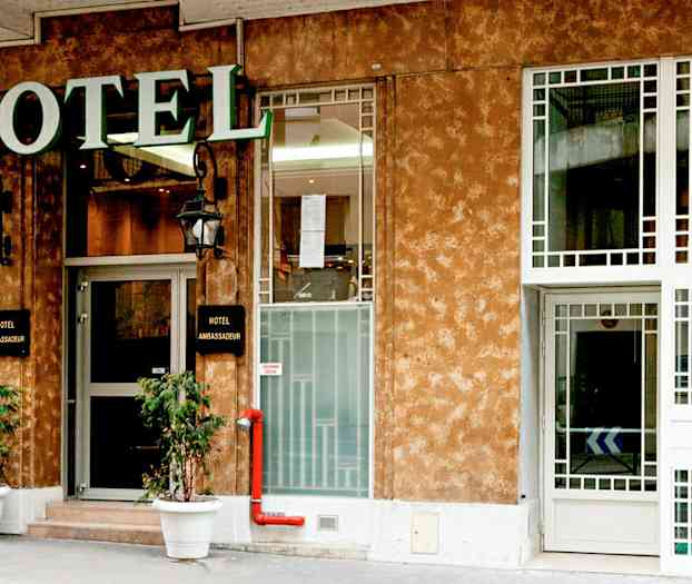 Forsiden av et hotell med et skilt som sier 'Hotel Ambassadeur'. (AI-generert tekst)