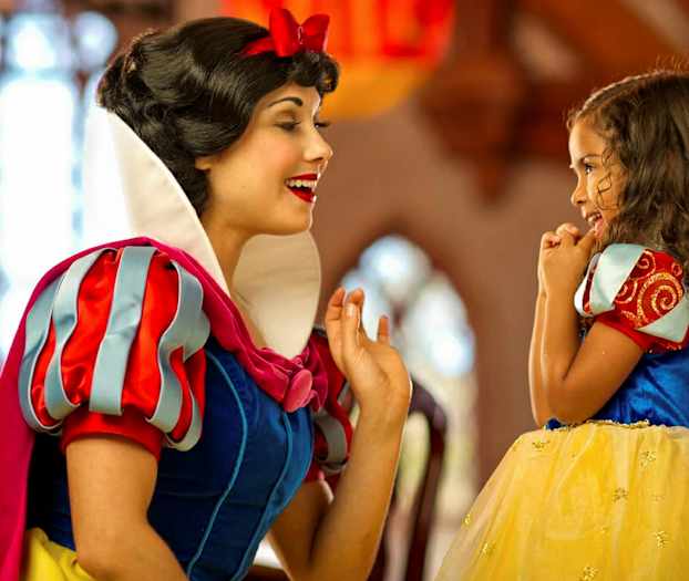 To personer er kledd som Snøhvit og en prinsesse i et fargerikt miljø. (AI-generert tekst)