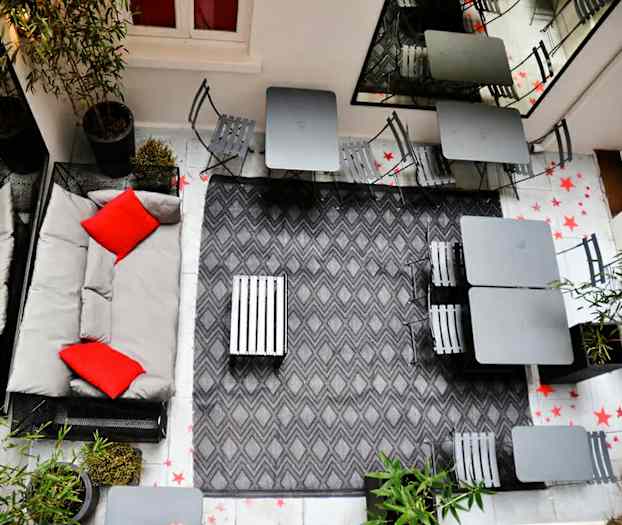 Innergårdsmiljø med sitteplasser og grå innredning. (AI-generert tekst)