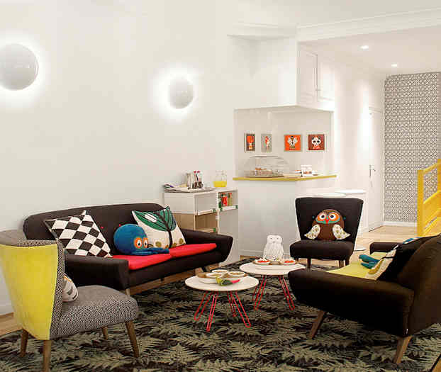 En stue med sofaer og lenestoler, pyntet med fargerike puter og et blomstrete gulv. (AI-generert tekst)