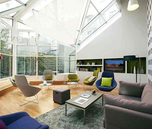 Moderne innredet loungrom med store vinduer og komfortable sitteplasser. (AI-generert tekst)