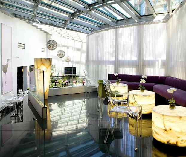 Moderne lounge med glasstak og lyse sittemøbler. (AI-generert tekst)