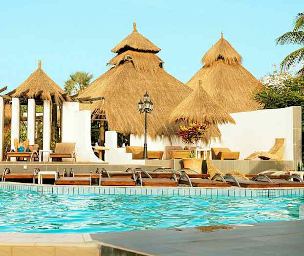 Bassengområde med stråtak og solsenger. (AI-generert tekst)