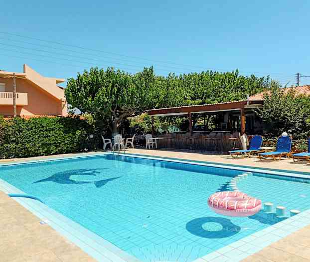 Et utendørsbasseng omgitt av solsenger og en frodig hage. (AI-generert tekst)