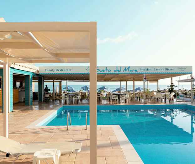 Bilde av et basseng ved en terrasse med restauranter ved havet. (AI-generert tekst)