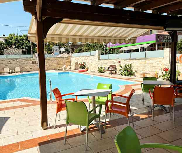 Utendørsbord med fargerike stoler ved et svømmebasseng. (AI-generert tekst)