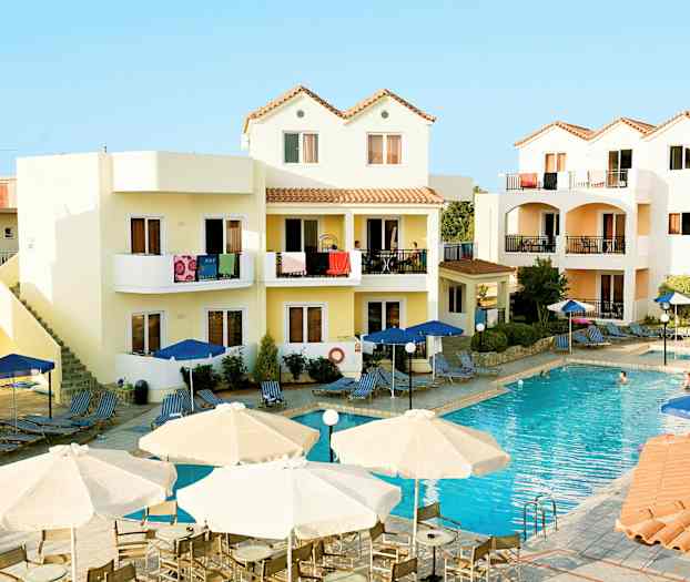 Et hotellområde med et basseng og omkringliggende bygninger med balkonger. (AI-generert tekst)