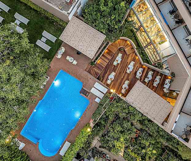 Bilde av et utendørsbasseng, solsenger og en treterrasse med sitteplasser. (AI-generert tekst)