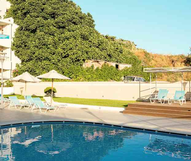 Et svømmebasseng med solsenger i en hotellmiljø. (AI-generert tekst)