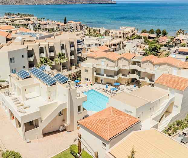 Hotellbygninger med basseng og hav i bakgrunnen. (AI-generert tekst)