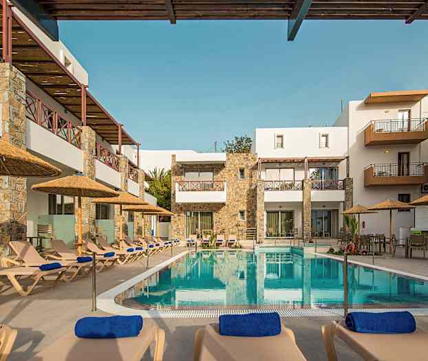 Hotellets bassengområde med solsenger og parasoller foran bygningen. (AI-generert tekst)