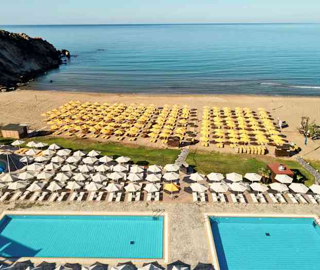 Utsikt over et bassengområde med solsenger og parasoller ved stranden. (AI-generert tekst)