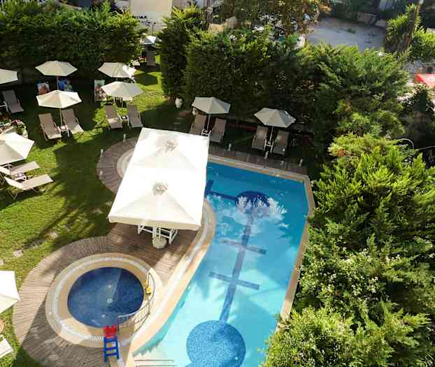 Utendørsbasseng med solsenger og parasoller omgitt av grøntområder. (AI-generert tekst)