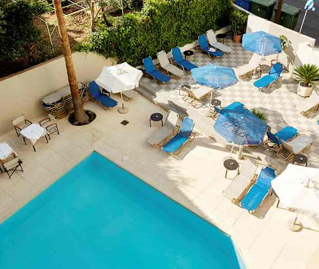 Solstoler og parasoller på en terrasse ved et basseng. (AI-generert tekst)