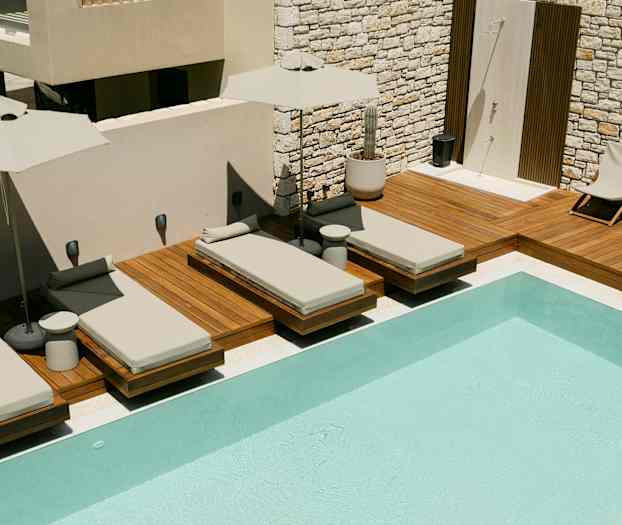 Solstoler ved et svømmebasseng på en treterrasse. (AI-generert tekst)