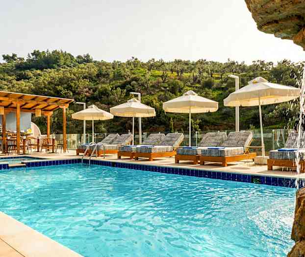 Utendørsbasseng med solsenger og parasoller, omgitt av grønne områder. (AI-generert tekst)