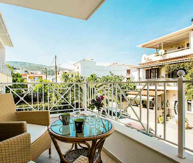 Balkong med utsikt over bolighus, trær og fjell. (AI-generert tekst)