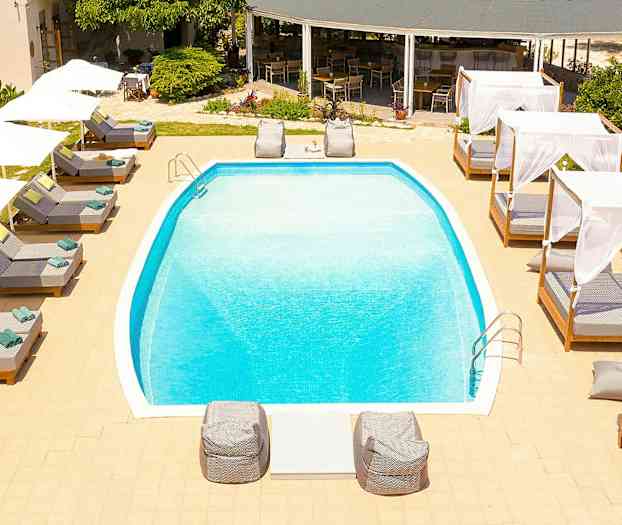 Utendørsbasseng omgitt av solsenger og baldakiner. (AI-generert tekst)