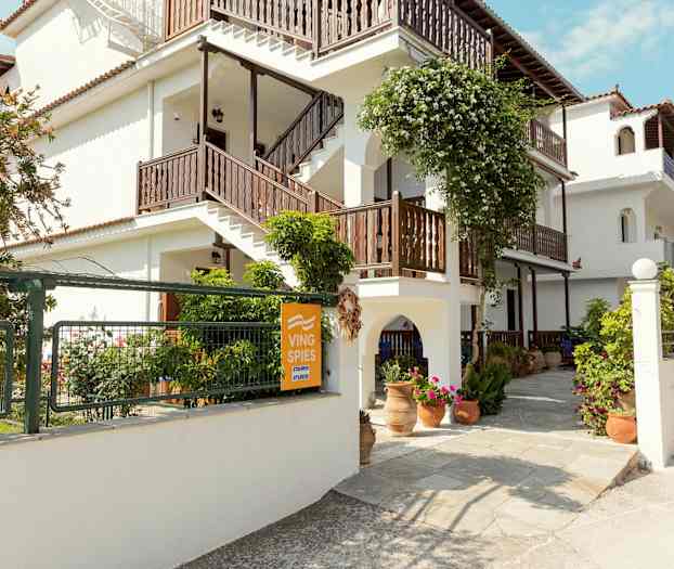 Hvit bygning med trapper og blomsterdekorasjoner utendørs. (AI-generert tekst)