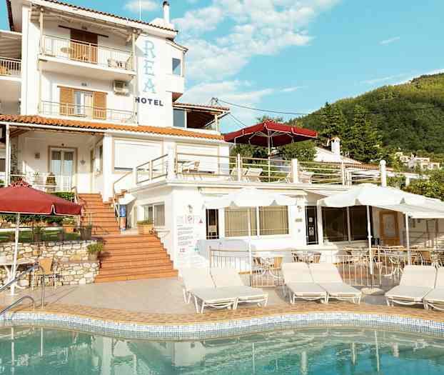 En hotellbygning med flere nivåer og et basseng i forgrunnen. (AI-generert tekst)