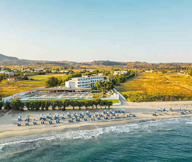 Strand og hotell med omkringliggende landskap. (AI-generert tekst)