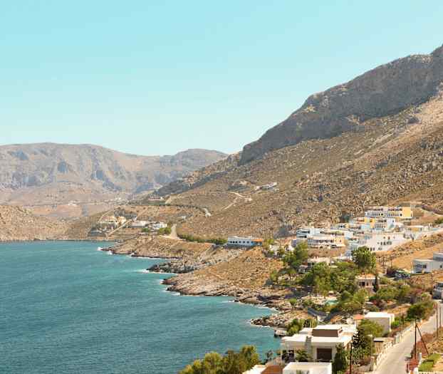 Kystby med fjell i bakgrunnen. (AI-generert tekst)