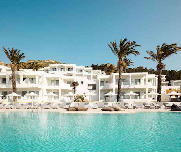 Hvit bygning med balkonger ved et basseng og palmetrær. (AI-generert tekst)