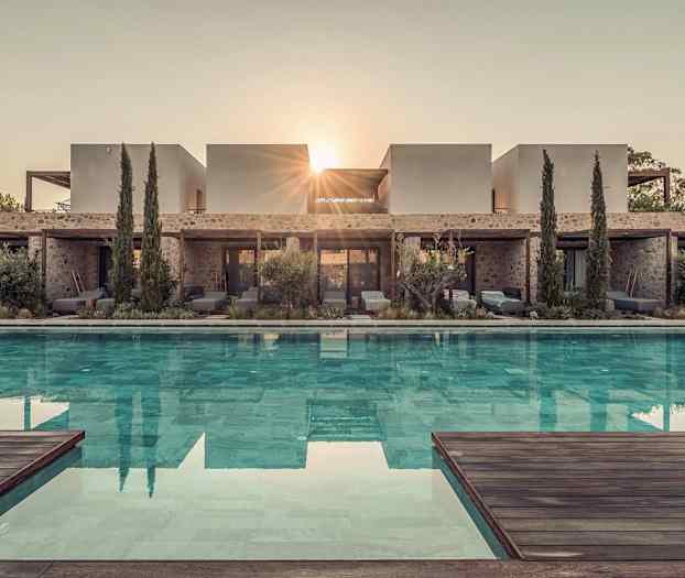 Bilde av en moderne villa med et basseng foran, omgitt av vegetasjon og trær, med solstrålene synlige bak bygningen. (AI-generert tekst)