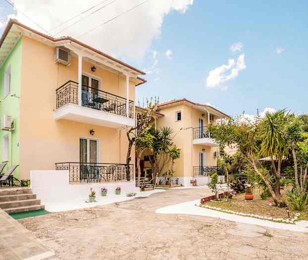 To små hus med balkonger omgitt av planter og trær. (AI-generert tekst)