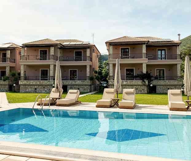 Tre hus med to etasjer og balkonger og et basseng med solsenger foran. (AI-generert tekst)